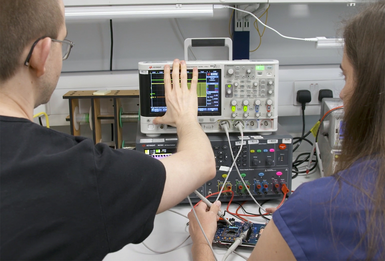 Cambridge Consultants engineers in an electronics lab monitoring Radio Frequency readings